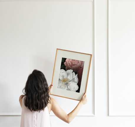4-1 A woman holding up a picture frame with flowers on it.